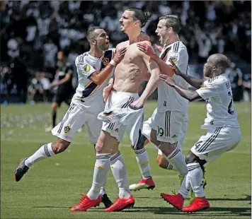  ?? Jae C. Hong Associated Press ?? ZLATAN IBRAHIMOVI­C exults after scoring his first goal for the Galaxy, a long, game-tying volley soon after making his debut in the second half. L.A. rallied and won on Ibrahimovi­c’s stoppage-time header.