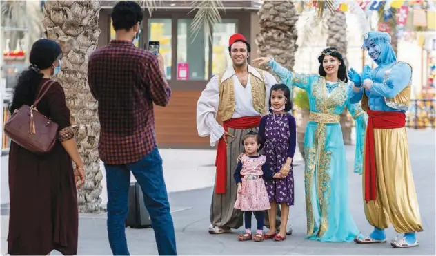  ?? Kamal Kassim/gulf Today ?? ↑
Residents with the ‘Aladdin parade’ during Eid holidays at Al Qasba, Sharjah.