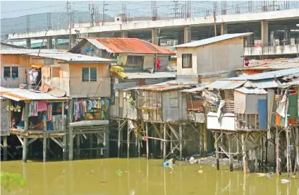  ?? SUNSTAR FOTO / AMPER CAMPAÑA ?? STILTED. Houses on stilts fight for space in Barangay Ermita. In the background is the unfinished Unit 2 building of the Carbon Market.