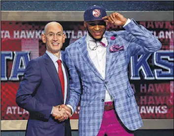  ?? MIKE STOBE / ?? The Hawks selected Michigan State forward Adreian Payne (left, shaking hands with NBA Commission­er Adam Silver on June 26) with the 15th overall pick in the 2014 NBA draft. He appeared in just three games with the Hawks before being traded Tuesday to...