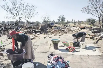  ?? Picture: Jacques Nelles ?? HOMELESS. Residents of a small farm in Capital Park wash their clothes outside what was once their homes. They were recently evicted by the Red Ants and their homes and belongings allegedly destroyed.