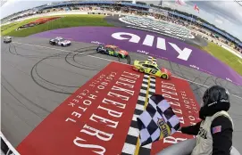  ?? (Logan Riely/getty Images) ?? Ryan Blaney, driver of the #12 Menards/cardell Cabinetry Ford, takes the checkered flag to win the Cup Series Firekeeper­s Casino 400 at Michigan Internatio­nal Speedway Sunday.