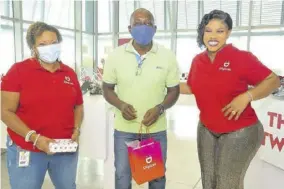  ??  ?? Longtime Digicel customer, Glenroy Nicholson is all smiles after being among the first to win a prize at the launch of the Digicel ‘Shake n Share’ promotion held on Thursday at the company’s store on the Kingston Waterfront. Nicholson accepted his prize from chief marketing officer for Digicel Nasha-monique Douglas (left) and Digicel Brand Ambassador Miss Kitty.