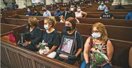  ?? AP ?? Mourners hold images of loved one during a memorial of Mexicans who died from Covid-19 at St. Patrick’s Cathedral in New York on Saturday.