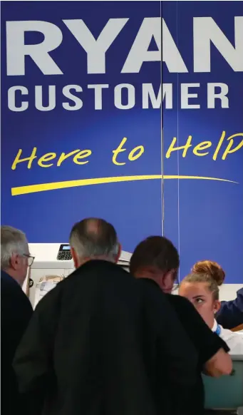  ??  ?? Passengers queue for a Ryanair customer service desk