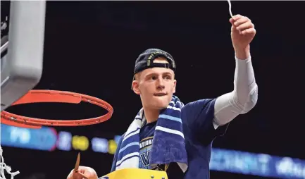  ??  ?? Villanova guard Donte DiVincenzo (10) cuts down the net after beating Michigan. BOB DONNAN/USA TODAY SPORTS