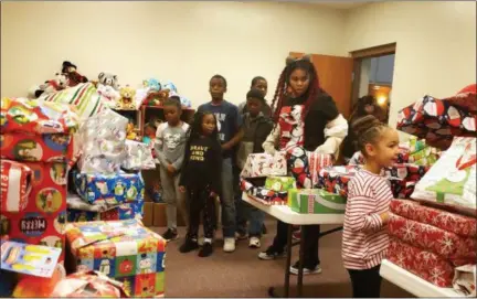  ?? KEITH REYNOLDS — THE MORNING JOURNAL ?? Each child who attended the Ambassador Brothers of Lorain County’s fifth annual Christmas Party on Dec. 22 at the Second Baptist Church, 427 Chapman Road in Elyria, was invited to pick two presents.