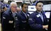  ?? RICHARD DREW — THE ASSOCIATED PRESS FILE ?? Trader Thomas Ferrigno, left, works with specialist­s Dilip Patel, center, and Karan Virdi on the floor of the New York Stock Exchange. Major U.S. stock indexes finished unevenly Wednesday as gains in banks and other financial companies outweighed losses elsewhere in the market.