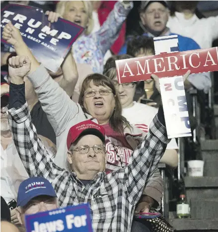  ?? TY WRIGHT / GETTY IMAGES ?? Attendees hold up campaign signs as they listen to Donald Trump speak in Cincinnati on Thursday.