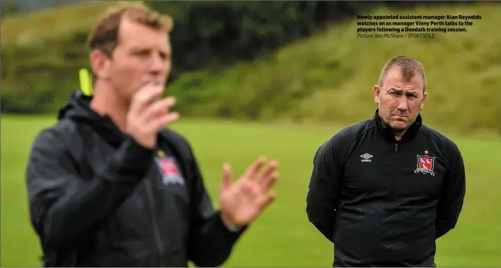  ??  ?? Newly appointed assistant manager Alan Reynolds watches on as manager Vinny Perth talks to the players following a Dundalk training session.