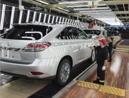  ?? TOYOTA MOTOR MANUFACTUR­ING CANADA ?? A Toyota worker in Cambridge does a final inspection of the paint and finish as the vehicles come off a Lexus RX line.