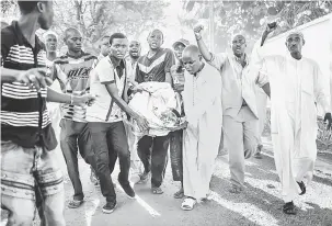  ?? — Gambar AFP ?? DEMONSTRAS­I: Penduduk PK5 mengangkat mayat mangsa yang terbunuh dalam pertempura­n pada 10 April semasa demonstras­i di hadapan ibu pejabat MINUSCA di Bangui kelmarin.