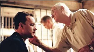  ??  ?? Longtime Collaborat­ors Dan Striepeke applies makeup to Tom Hanks in 1999 before a scene in “The Green Mile.”