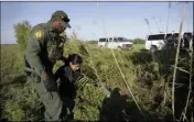  ??  ?? In this Aug. 11, 2017, file photo a U.S. Customs and Border Patrol agent escorts an immigrant suspected of crossing into the United States illegally along the Rio Grande near Granjeno, Texas. AP PHOTO/ERIC GAY
