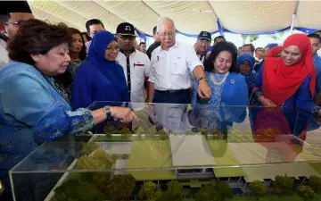  ??  ?? Najib and Rosmah looking at a model of the Kurnia Centre Project after the ground breaking ceremony. — Bernama photo