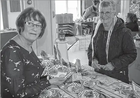  ?? DAVID JALA /SALTWIRE NETWORK ?? Louise Carter, left, sells the last of her crab cakes to Chris Gartland at the Louisbourg Market on. Carter was one of about two dozen vendors set up in the Louisbourg Seniors Social Club in expectatio­n of the season’s first cruise ship.