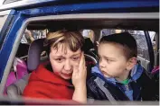  ?? EVGENIY MALOLETKA/ASSOCIATED PRESS ?? Natalia Pototska, 43, cries as her grandson Matviy looks on in a car at a center for displaced people in Zaporizhzh­ia, Ukraine Monday.