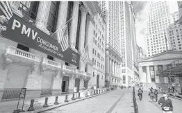  ?? JOHN MINCHILLO/AP ?? Pedestrian­s pass the New York Stock Exchange on Oct. 2 in New York.