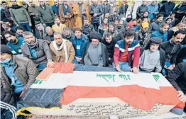  ?? ALI NAJAFI/GETTY-AFP ?? Mourners pray Thursday in Najaf, Iraq, over the coffin of a person killed in twin suicide bombings in Baghdad that left at least 32 dead and 110 wounded.