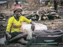  ??  ?? ON THE MOVE: A refugee from Kajo Keju, South Sudan sits with her suitcase in Palorinya refugee camp, Uganda. Thousands have fled here from neighbouri­ng South Sudan after fighting erupted, bringing only what they could carry.