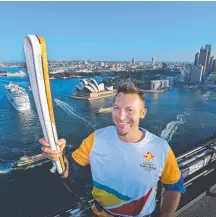  ??  ?? Swimmer Ian Thorpe holds it above Sydney harbour.