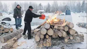  ?? CP PHOTO ?? Gerald Moise, father of shooting victim Dayne Fontaine, 17, pours gas on a fire prepares to soften the ground to dig a grave in La Loche, Sask., Monday. A 17-year-old boy allegedly shot and killed Moise and three others.