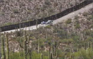  ?? MATT YORK/AP ?? U.S. CUSTOMS AND BORDER PATROL AGENTS sit along a section of the internatio­nal border wall that runs through Organ Pipe Cactus National Monument on Aug. 22, 2019 in Lukeville, Ariz.