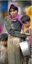  ?? AP ?? A Rohingya woman carries her child across Bangladesh.—