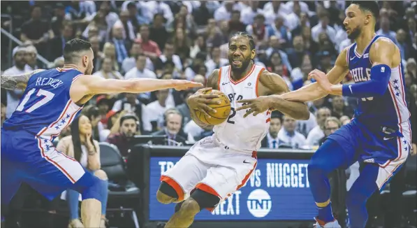  ?? ERNEST DOROSZUK ?? The Raptors’ Kawhi Leonard drives between the 76ers’ JJ Redick (left) and Ben Simmons last night at Scotiabank Arena.