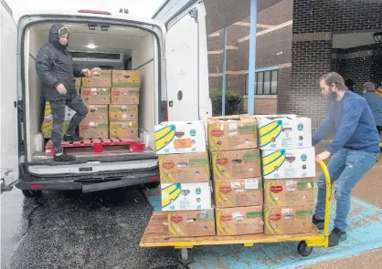  ?? ANDY LAVALLEY/POST-TRIBUNE ?? Maintenanc­e technician Jake Nauracy pulls a cart of boxes containing Backpacks on the Go after unloading them from the NWI Food Bank truck outside Miller Elementary School in Merrillvil­le on Thursday.