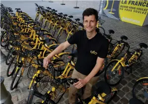  ??  ?? OFO FRANCE general manager Laurent Kennel poses with city bike-sharing service Ofo bicycles at the Autonomy urban-mobility conference in Paris last week.