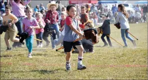  ?? ?? Children from 3 to 7 years of age enjoyed a stick mule race, rounding barrels encouraged by Ms. Jessica Funk at the 33rd annual Pea Ridge Mule Jump.