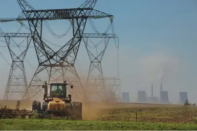  ?? DENIS FARRELL/AP ?? Land is plowed last week under electrical pylons leading from the coal-fired Duvha power plant east of Johannesbu­rg. Residents of the nearby Masakhane township fear job losses if the facility is closed as the country begins to move toward cleaner energy.