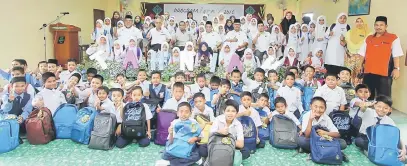  ?? — Gambar Bernama ?? BANTU: Izmi (tengah) dan Pengarah Tabung Haji Negeri Perlis Amat Kassim Pait bergambar kenangan bersama penerima sumbangan pada Program Iqra Tabung Haji di Sekolah Kebangsaan Kampung Salang dekat Kangar, semalam.