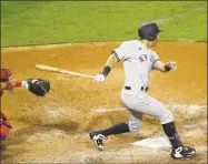  ?? Matt Slocum / Associated Press ?? The New York Yankees’ Mike Tauchman follows through after hitting an RBI double off Philadelph­ia Phillies relief pitcher Tommy Hunter during the seventh inning of the second game in a doublehead­er on Wednesday.