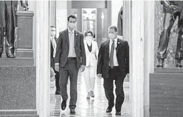  ?? ANDREW HARNIK/AP ?? Face mask-wearing members of Congress head to the House Chamber on Thursday to vote on the latest relief bill.