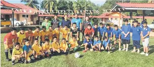  ??  ?? BAKAT BAHARU: Fredercik (berdiri tiga kiri) bersama pemain-pemain Liga Bola Sepak Bawah 12 Tahun di Padang SK Bandar Limbang kelmarin.