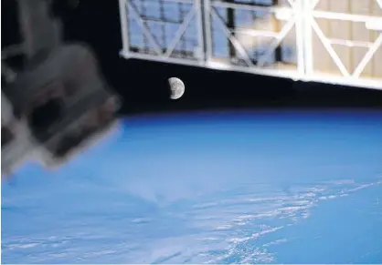  ?? NASA ?? The moon, pictured during a lunar eclipse on May 26, 2021, is seen from the Internatio­nal Space Station during a northwest to southeast orbital trek 263 miles above the Pacific Ocean. When the sun is close to a lunar node, and the full moon is near the node as well, a lunar eclipse occurs.