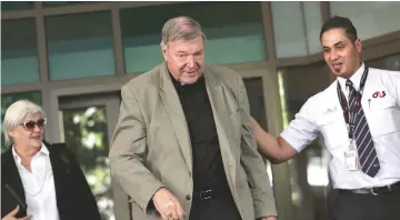  ??  ?? Pell (centre) leaves the court during his hearing at the Melbourne Magistrate­s Court after being charged with historical sexual assault offences in Melbourne. — AFP photo