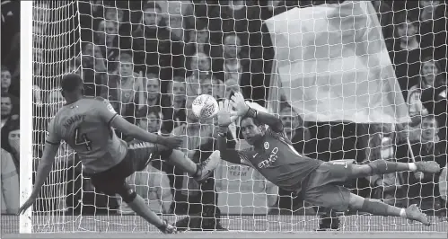  ?? Photo: VCG ?? Claudio Bravo of Manchester City saves a penalty from Alfred N’Diaye of Wolverhamp­ton Wanderers during the English League Cup fourth-round match at Etihad Stadium on Tuesday in Manchester, England.