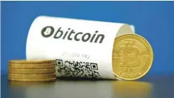  ?? — Reuters ?? A bitcoin (virtual currency) paper wallet with QR codes and a coin are seen in an illustrati­on picture taken at La Maison du Bitcoin in Paris.