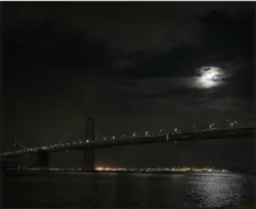 ?? ?? The moon rising over the Bay Bridge after a decade-old
LED light display was turned off, in San Francisco on Monday. The artwork created by Leo Villareal, known as the Bay Lights, was installed in March 2013 as an adornment to the span that has often been overshadow­ed by the nearby Golden Gate Bridge.
