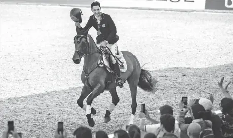  ?? XINHUA ?? London-based Chinese rider Alex Hua Tian savors the moment after winning eventing bronze on board PSH Convivial, aka Spike, at the Asian Games on Sunday.