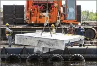  ?? LANNIS WATERS / THE PALM BEACH POST ?? Workers lower a slab of concrete into the Intracoast­al Waterway Tuesday, part of a project to create a 2-acre artificial reef that can serve as a habitat for fisheries.