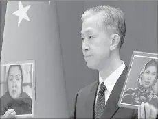  ??  ?? BEIJING
Chinese Foreign Ministry spokesman Wang Wenbin holds pictures while speaking during a news conference in Beijing, China. -APP