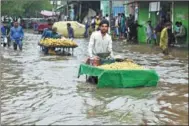  ?? SAJJAD / XINHUA ?? Fruit vendors push their carts through a flooded street on Juen 26 after heavy rainfall lashed Lahore, Pakistan. The countrywid­e death toll from rain-related incidents since June 25 rose to 23, officials said.