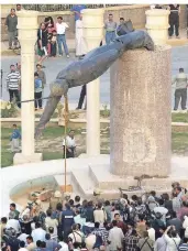 ?? FOTO: DPA ?? Iraker schauen am 9. April 2003 zu, wie die Statue von Saddam Hussein auf dem Firdos-Platz in Bagdad zu Fall gebracht wird.
