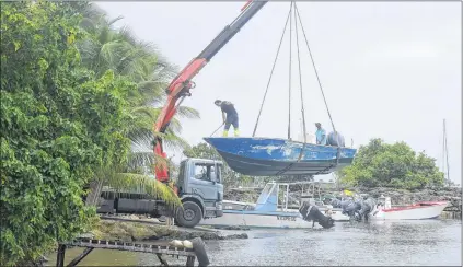  ?? AP PHOTO ?? Men remove boats from the water ahead of hurricane Maria in the Galbas area of Sainte-anne on the French Caribbean island of Guadeloupe, early Monday.