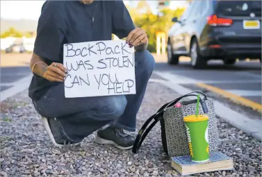  ?? GABRIELA CAMPOS/THE NEW MEXICAN ?? A panhandler holds her sign at the intersecti­on of Paseo de Peralta and North Guadalupe Street on Tuesday afternoon. She said her backpack containing many of her personal items was stolen at a shelter recently and now it is more important for her to try and raise money through panhandlin­g.