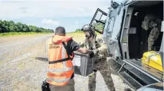  ?? PHOTO: NZDF VIA REUTERS ?? Special cargo . . . A New Zealand Defence Force member hands a ballot box to an election official, standing next to an NH90 helicopter, in a remote area of the Solomon Islands, this week.